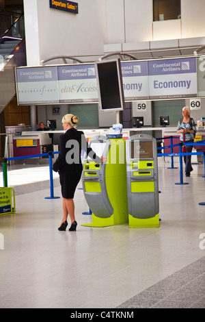 Il terminale 2, Aeroporto di Manchester, Inghilterra, vacanze Valigia controllo automatico in macchine green free standing Foto Stock