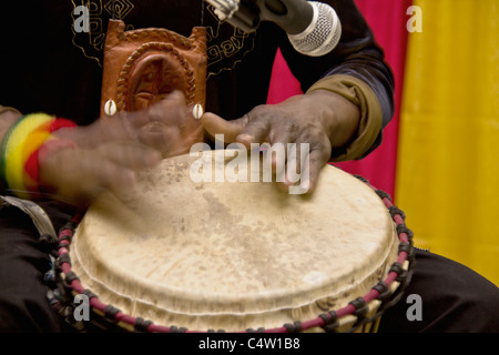 Un uomo africano giocando un tamburo tradizionale a mano Foto Stock