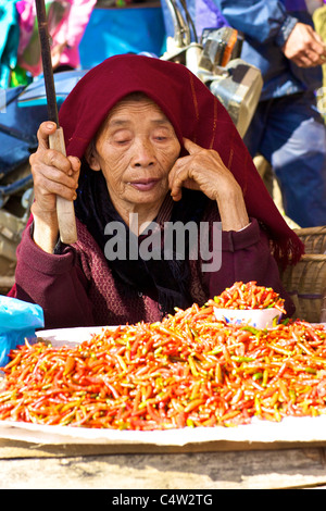 Non identificato donna vietnamita chilis vendita al mercato di Bac Ha, Vietnam. Foto Stock