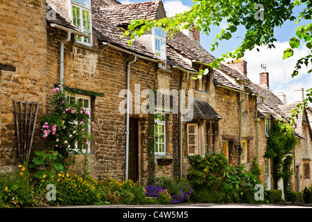 Fila di pretty Cotswold cottage in pietra nella città turistica di Burford, Oxfordshire, England, Regno Unito Foto Stock