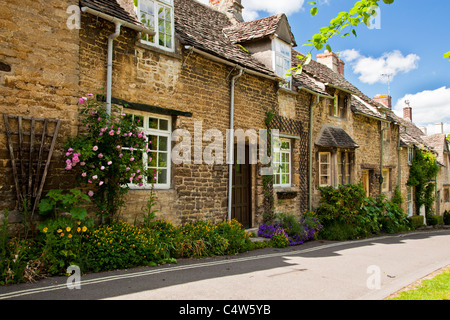 Fila di pretty Cotswold cottage in pietra nella città turistica di Burford, Oxfordshire, England, Regno Unito Foto Stock