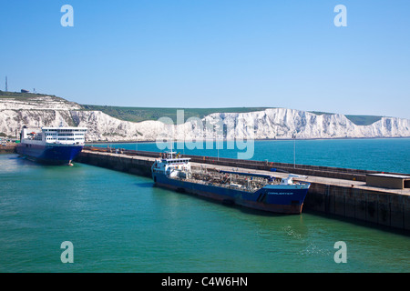 Scogliere Bianche di Dover e del carico di una nave e traghetto ormeggiate lungo la parete del porto. Foto Stock