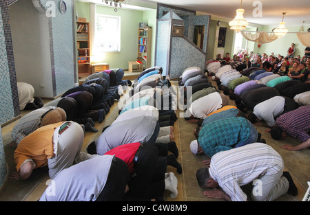 Musulmani turchi (anteriore) guardato da cristiani tedeschi (retro) durante una preghiera del venerdì nella moschea di Dresda, in Germania. Foto Stock