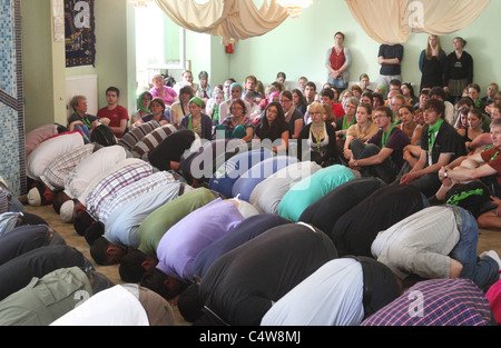 Musulmani turchi (anteriore) guardato da cristiani tedeschi (retro) durante una preghiera del venerdì nella moschea di Dresda, in Germania. Foto Stock