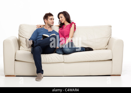 Coppia sorridente cercando romanticamente a ogni altro libro Foto Stock