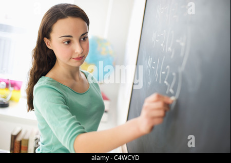 Stati Uniti d'America,New Jersey,Jersey City,ragazza adolescente (14-15) di scrivere sulla lavagna Foto Stock