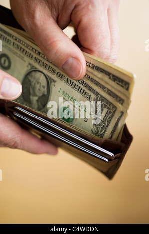 Close-up di uomo di mani portafoglio con banconote di dollari Foto Stock