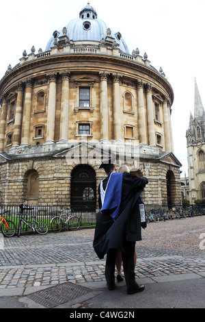 Uno studente nelle vesti della Università di Oxford si trova di fronte la Radcliffe Camera. Foto Stock