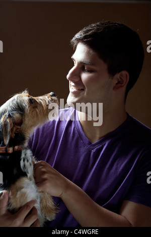 Tasto basso ritratto di una giovane azienda un simpatico razza terrier cane isolate su uno sfondo scuro. Foto Stock