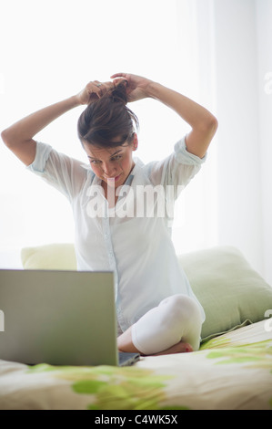 Giovane donna attraente utilizzando laptop Foto Stock