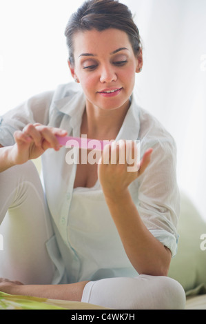 Attraente giovane donna chiodi di deposito Foto Stock