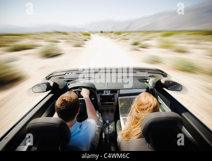 Stati Uniti, California, Palm Springs, Coachella Valley, San Gorgonio Pass, giovane guidando attraverso il deserto in autovettura convertibile Foto Stock