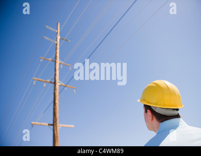 Stati Uniti, California, Palm Springs, Coachella Valley, San Gorgonio Pass, uomo in hard hat guardando un palo telefonico Foto Stock