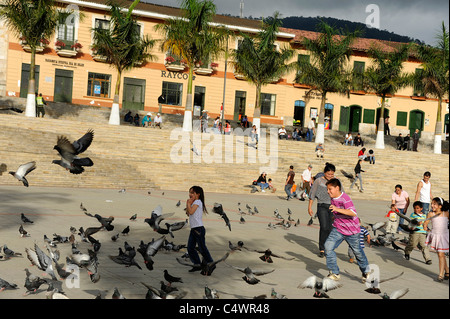 I Bambini a caccia di piccioni in Piazza centrale di Fusagasuga, Colombia, Sud America Foto Stock