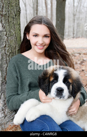 Stati Uniti d'America, New Jersey, Califon, ragazza adolescente (16-17) seduta con san Bernardo cucciolo su giri, ritratto Foto Stock