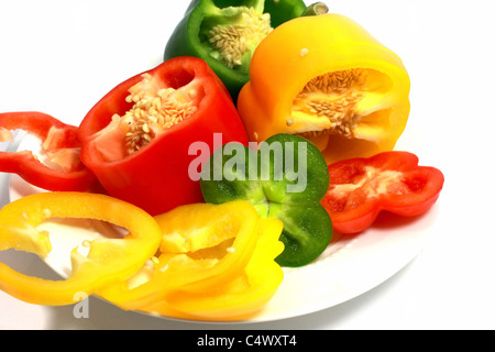 Tagliare il dolce rosso, giallo e i peperoni verdi isolati Foto Stock