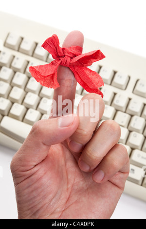 Arco rosso sul dito e della tastiera del computer Foto Stock