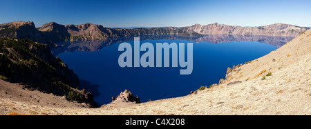 Parco nazionale di Crater Lake noi bordo calderico riflessioni a specchio blu acqua parete del cratere panorama di riflessione piena vista lago blu cielo ancora acqua ci Oregon Foto Stock