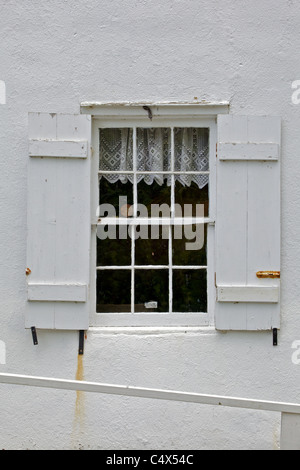 Legno bianco finestra contro un intonaco bianco parete Foto Stock