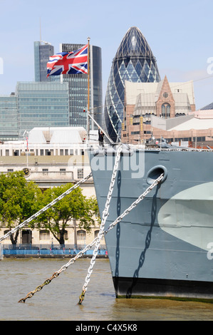 Union Jack volando a prua della storica nave museo HMS Belfast con City of London skyline del grattacielo punto di riferimento ufficio blocchi Inghilterra Regno Unito Foto Stock
