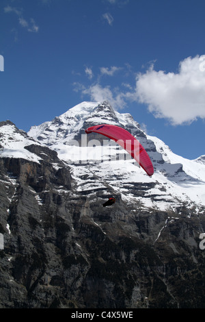 Parapendio prendendo per i cieli sopra Gimmelwald, con Jungfrau in background Foto Stock