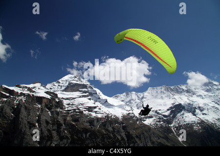 Parapendio prendendo per i cieli sopra Gimmelwald, con Jungfrau in background Foto Stock