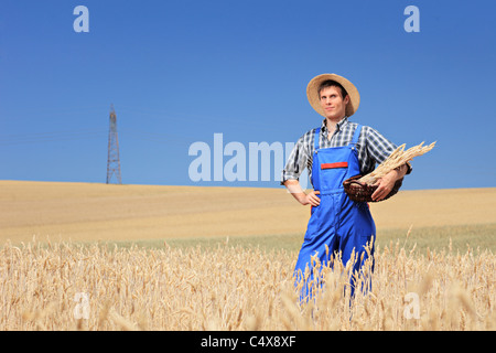 Un agricoltore con cappello di Panama tenendo un cesto in un campo Foto Stock