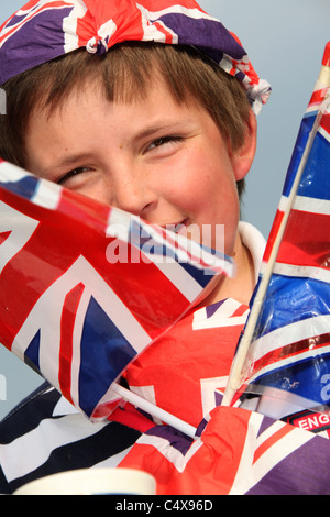 Close up ritratto di un giovane ragazzo che sorride mentre adornata con Union Jack Flag e altri paraphernalia britannico. Foto Stock