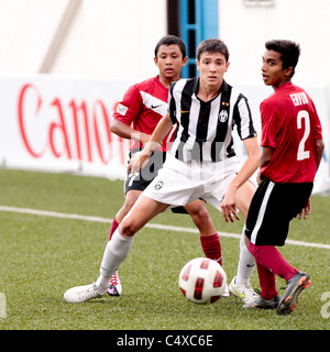 Gili Fabio della Juventus FC U15(centro) passano sulla sfera come Zulfadhmi Suzliman(a sinistra) e Ehvin Sasidharan guarda su Foto Stock