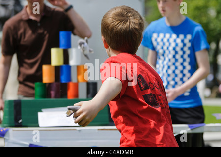 Ragazzo getta bean bag in barattoli in fiera gioco " stagno può Alley' Foto Stock