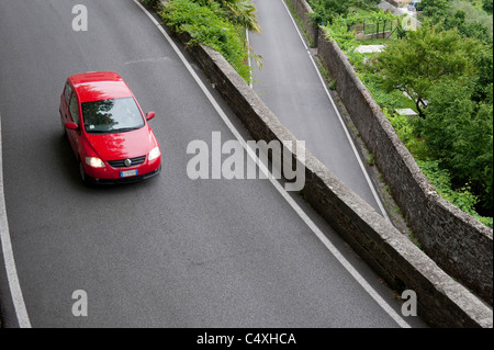 La torsione strada curva e unica auto rossa Foto Stock