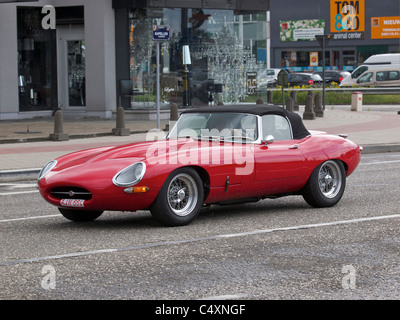 Rosso brillante vintage Jaguar E-type convertibile in marcia per le strade di Anversa, Belgio Foto Stock