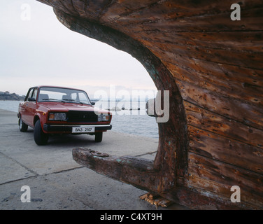 Un nuovo Russian Lada Automobile, Nessebar resort, Mar Nero, parcheggiato dietro di una vecchia imbarcazione, Bulgaria, Europa orientale Foto Stock