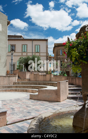 La piazza del paese e una fontana in Bizanet nel Languedoc-Roussillon, Francia in una giornata di sole Foto Stock