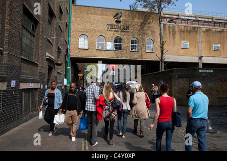 People shopping in strada dei mercati al di fuori del Vecchio Truman Brewery in Brick Lane, London, England, Regno Unito Foto Stock