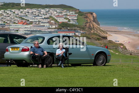 Coppia senior seduto in parcheggio, cromer, Norfolk, Inghilterra Foto Stock
