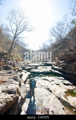 Un escursionista passeggiate donw un fiume gorge Foto Stock