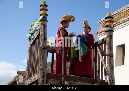 Due giovani Dalai Lama tempio di monaci soffiando una conchiglia al di fuori del Dalai Lama tempio presso il monastero di Erdene-Zuu Foto Stock