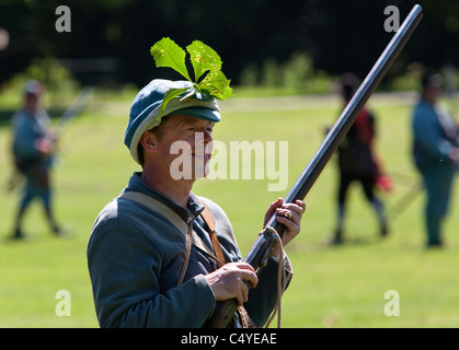 Un membro della guerra civile inglese la Società detiene il suo moschetto durante una battaglia rievocazione nel Wiltshire. Foto Stock