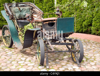 Antica verde carrello con ruote metalliche con lo sfondo della natura Foto Stock