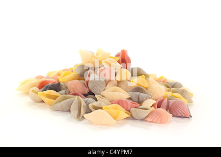 Una manciata di pasta colorata su sfondo bianco Foto Stock