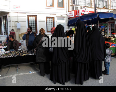 Turchia Istanbul distretto occidentale una più conservatore quartiere islamico. Le donne in nero Burka shopping al mercato aperto Foto Stock