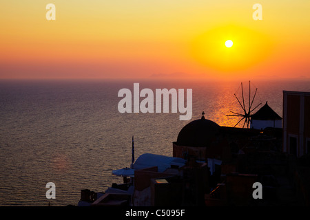 Tipico di Santorini iconico isola greca tramonto a Oia caldera giallo brillante la silhouette della città illuminata dal sole Foto Stock