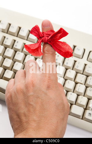 Arco rosso sul dito e della tastiera del computer Foto Stock