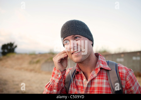 Uomo di mettere gli auricolari in zona remota Foto Stock