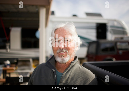 Senior uomo caucasico seduto fuori casa a motore Foto Stock