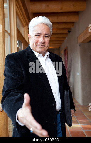 Imprenditore ispanica tenendo fuori mano Foto Stock