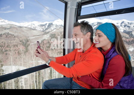 Paio di equitazione in gondola di sci insieme scattare fotografie Foto Stock