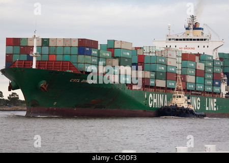 CSCL Oingdao nave container essendo assistita da rimorchiatori fino al Fiume Yarra a Swanson Docks Melbourne Australia Foto Stock