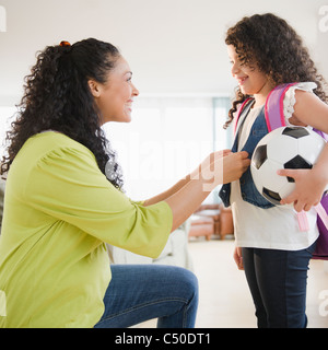 Madre figlia di medicazione tenendo palla calcio Foto Stock